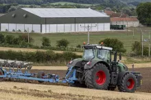 A tractor plowing a field in the countryside of North Yorkshire in the United Kingdom.