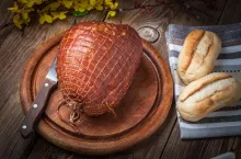 Whole ham on a wooden table, selective focus.