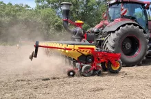 siewnik przyczepiony do cięgnika rolniczego podczas pracy