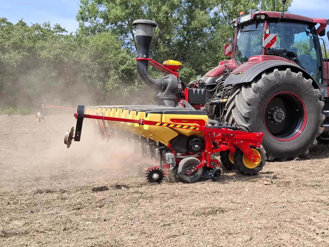 siewnik przyczepiony do cięgnika rolniczego podczas pracy