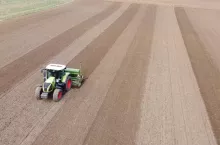 Traktor jadący po polu z siewnikiem