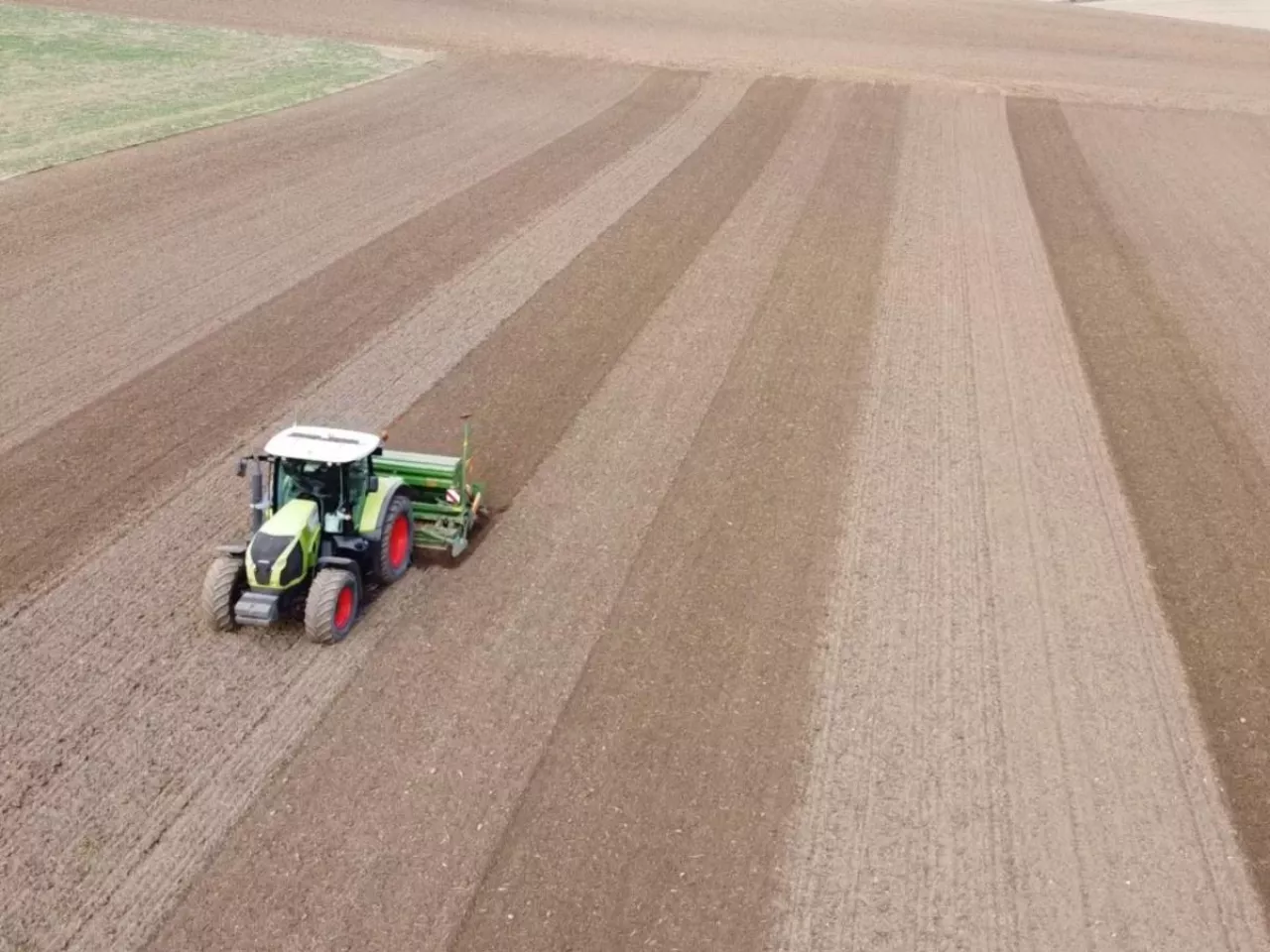 Traktor jadący po polu z siewnikiem