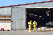 Strażacy w strojach ochronnych podczas utylizacji kurnika z ptasią grypą