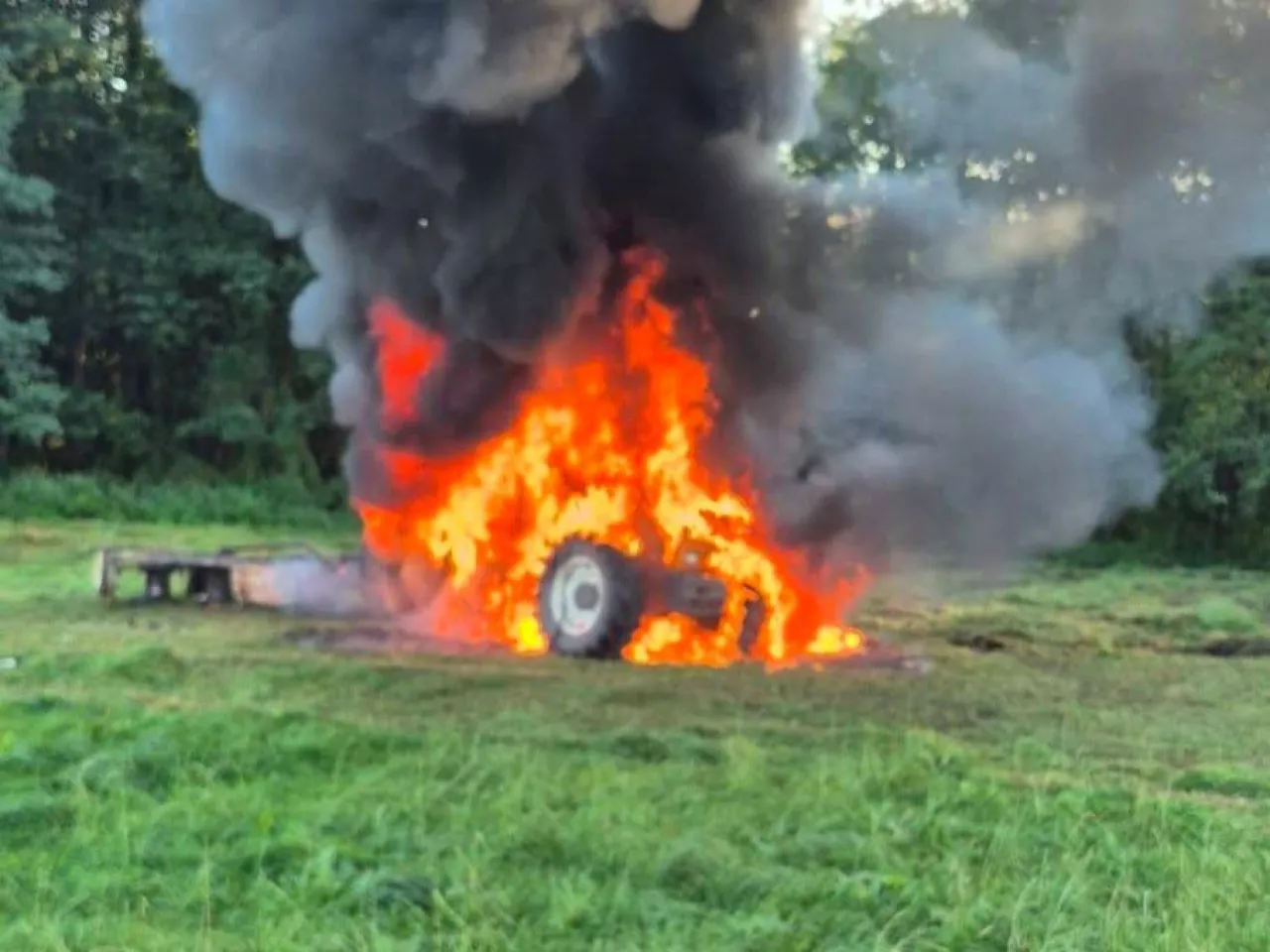 Płomienie w całości ogarnęły ciągnik rolniczy, który płonie na łące