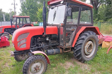 Czerwony ciągnik marki Ursus na trawniku