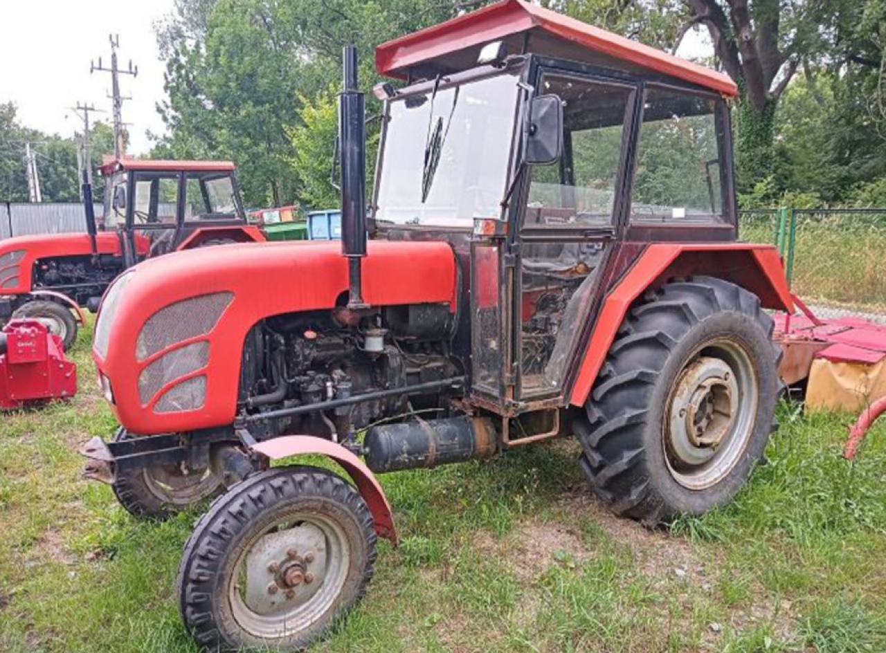 Czerwony ciągnik marki Ursus na trawniku