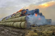 Palące się baloty na jednym z pól