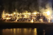 Nocne zdjęcie przedstawiające palące się około 500 sztuk balotów