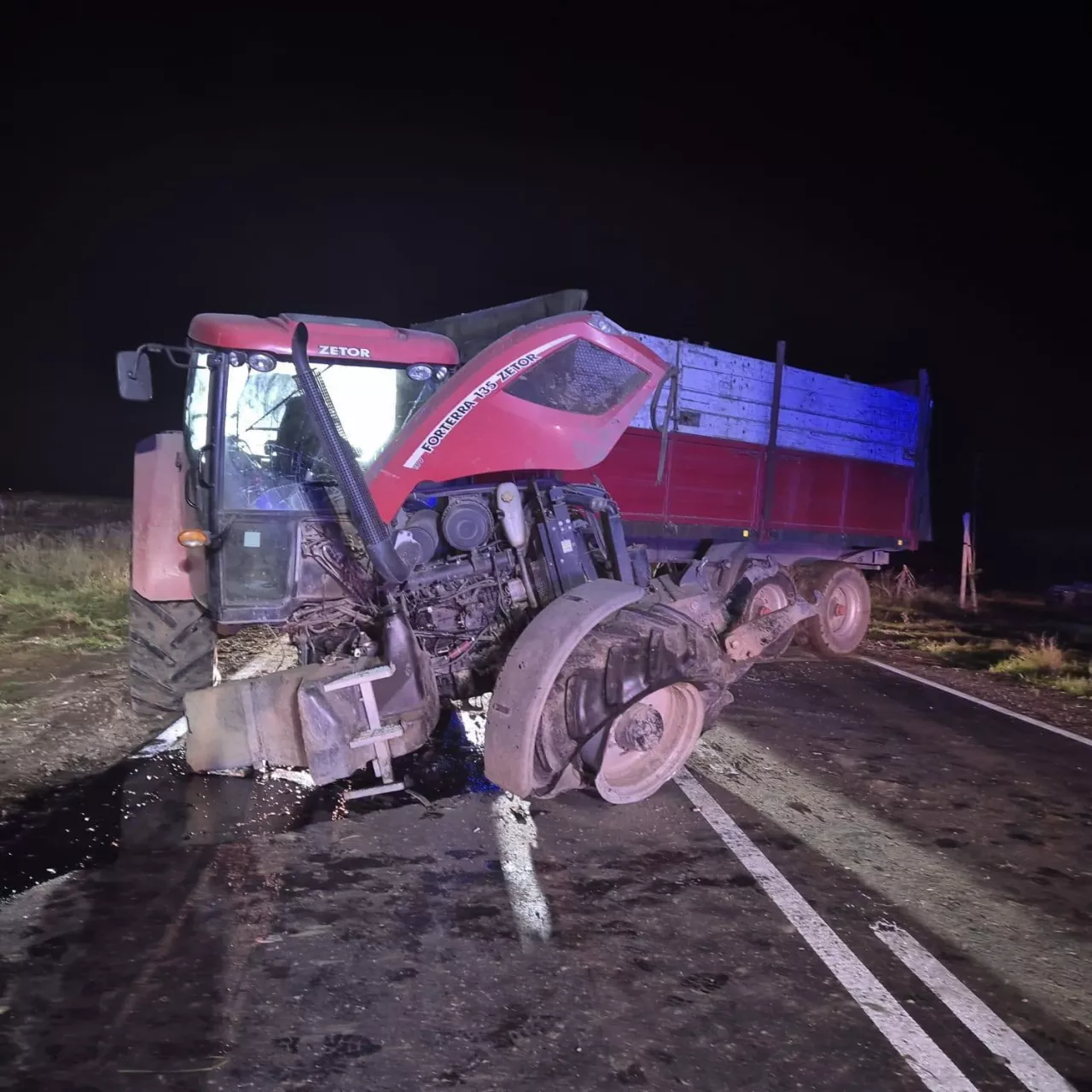 Czerwony Zetor poważnie uszkodzony po wypadku blokuje drogę