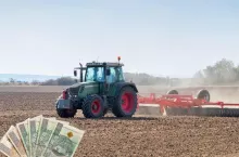 ciągnik rolniczy podczas orki w polu i gotówka