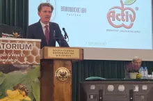 Mężczyzna w garniturze przed mównicą podczas konferencji