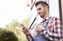 rolnik z telefonem czyta wiadomość SMS