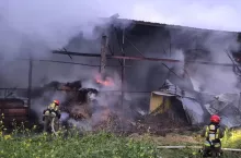 strażacy w ubraniach specjalnych walczą z pożarem gospodarstwa rolnego