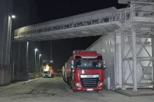 Czerwona ciężarówka ze zbożem stojąca przy terminalu zbożowym