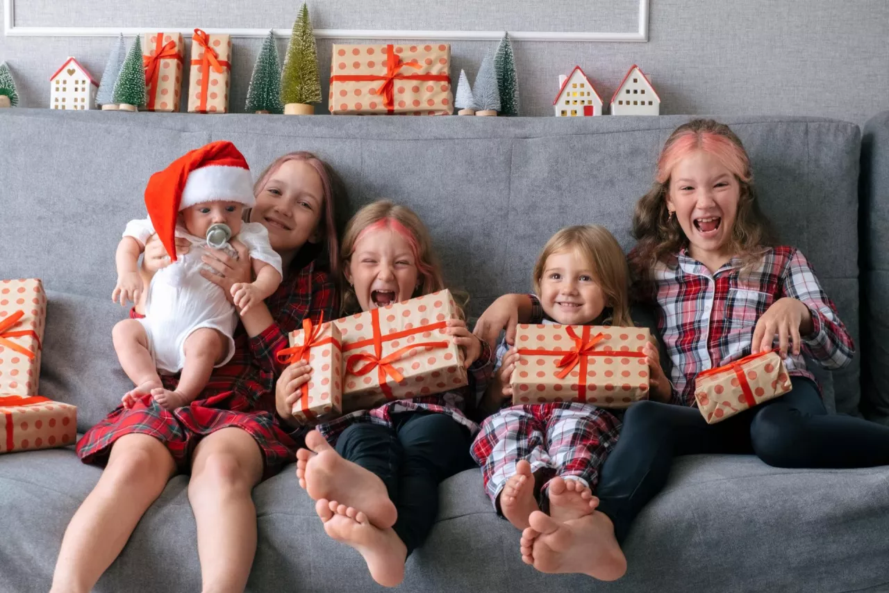 dzieci na kanapie z prezentami mikołajkowymi