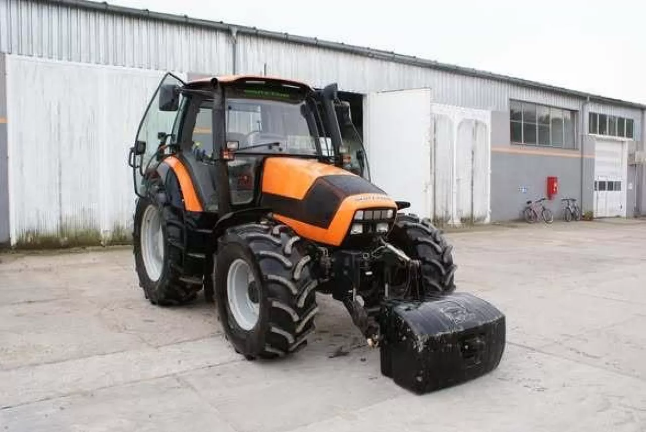 Pomarańczowy ciągnik rolniczy na parkingu