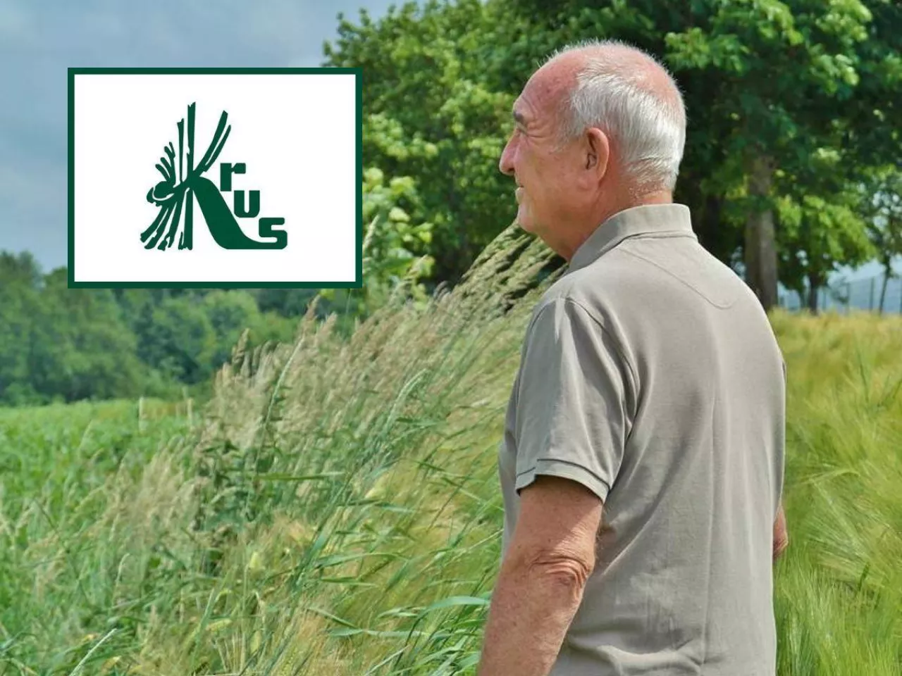 starszy rolnik stoi bokiem i patrzy na pole, po lewej u góry logo krus
